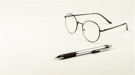 Premium Photo Pen And Glasses On White Desk Background