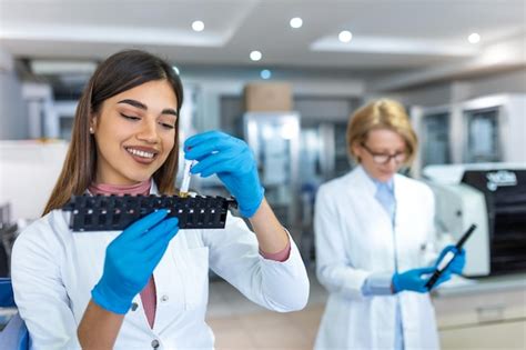 Assistente Di Laboratorio Che Mette Le Provette Nel Supporto Medico