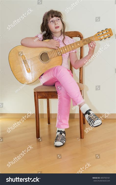 Young Little Girl Playing Acoustic Guitar Stock Photo 409793101