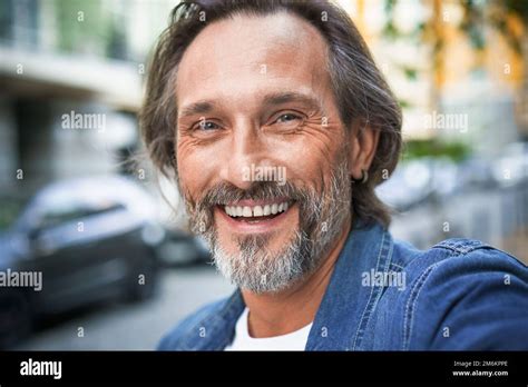 Happy Senior Man On Street Of European City Making Selfie Using Mobile