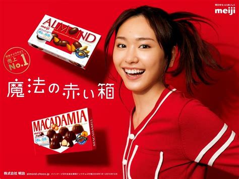 An Advertisement For Macadamia Chocolates With A Smiling Woman In Front