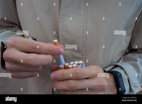 hands of a man pulling a cigarette from a cigarette pack. flipped ...