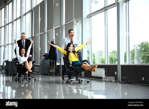 Cheerful Colleagues Having Fun In Office Chairs Stock Photo Alamy