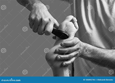 Male Masseur Hands Doing Massage On Female Foot Reflex Zone In The Spa Salon Using Gua Sha