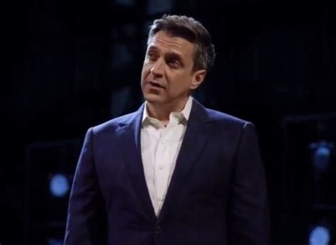 A Man In A Suit Is Standing On Stage