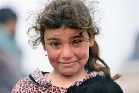 A displaced Iraqi girl, who fled her home, smiles through her tears ...