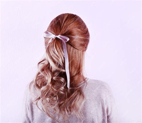 Premium Photo | Female hairstyle with color ribbon on white wall background