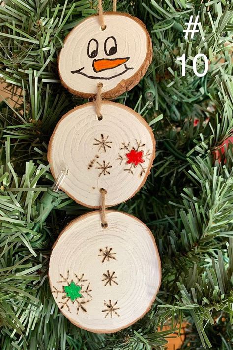 Three Wood Slices With Snowmen Painted On Them Hanging From A Christmas