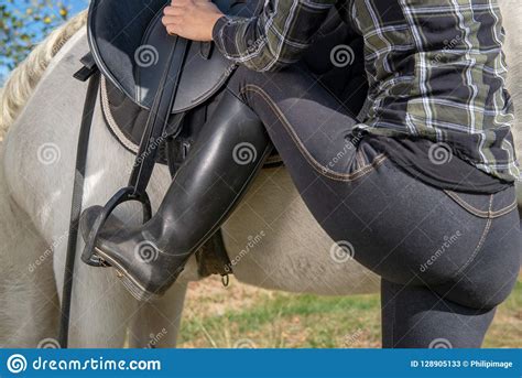 Feche Acima Do Cavaleiro Da Jovem Mulher Que Monta Um Cavalo Branco