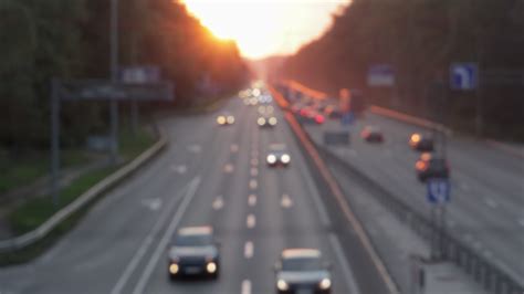 Moving cars on the motorway during sunset. Busy traffic on a freeway or