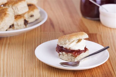 Scones Con La Mermelada De Fresa Y La Crema Azotada Foto De Archivo