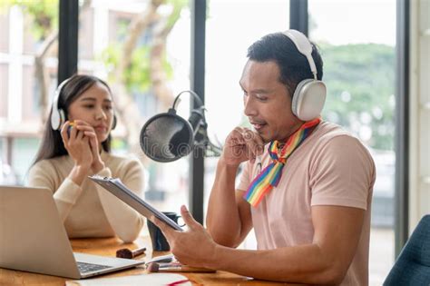 A Focused Asian Gay Man Radio Host Is Talking And Interviewing His