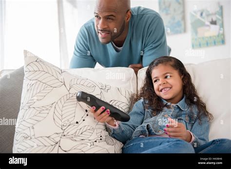 Padre e hija en el sofá viendo televisión Fotografía de stock Alamy