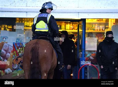 A Mounted Police Officer By A Store As Fans Gather Outside Before The