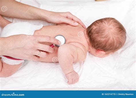 Newborn Medical Exam Doctor Checking Heart Beat And Lungs With