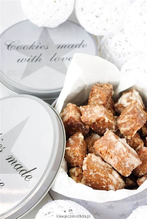 Two Tins Filled With Food Sitting On Top Of A White Doily Covered Table