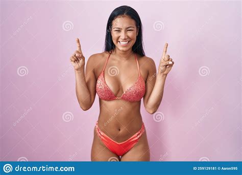 Hispanic Woman Wearing Bikini Smiling Amazed And Surprised And Pointing