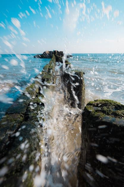 Una Ola Rompe Sobre Una Barrera Que Tiene La Palabra Mar Foto Premium