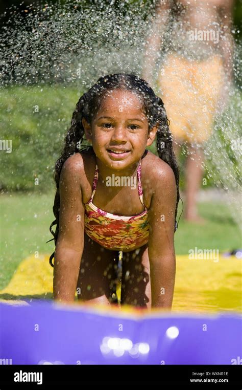 Ethnic kids on water slide hi-res stock photography and images - Alamy