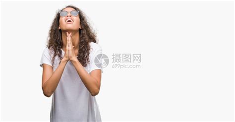 身戴太阳镜的年轻西班牙妇女用双手乞讨和祈祷高清图片下载 正版图片504079146 摄图网