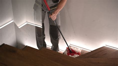 Caucasian Men in His 30s Mopping Wooden Stairs Inside His Home