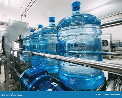 Blue Plastic Bottles With Purified Drinking Water On Automated Conveyor