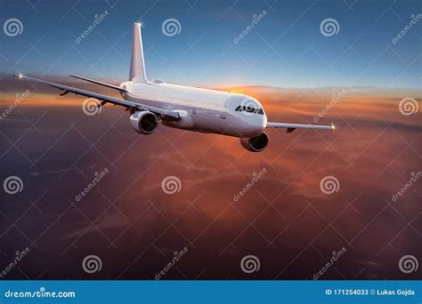 Commercial Airplane Jetliner Flying Above Dramatic Clouds Stock Image