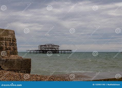 A View Of The Ruined West Pier From Brighton Beach On A Grey Summer`s