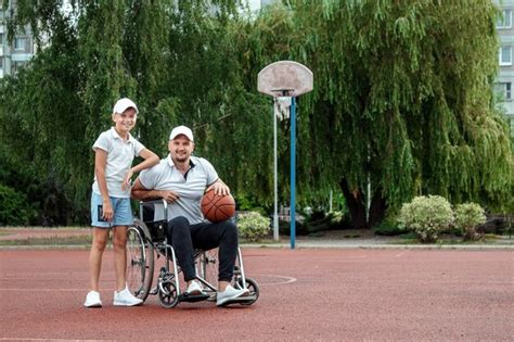 Premium Photo A Man In A Wheelchair Plays Basketball With His Son On