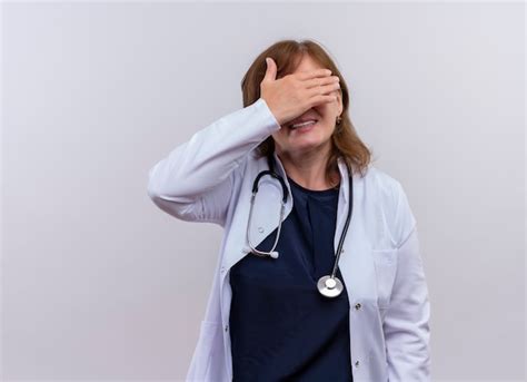 Sonriente mujer de mediana edad médico vistiendo bata médica y