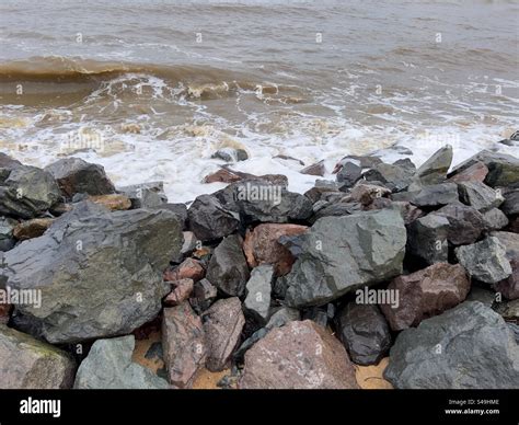 Rocky beach with sea waves hitting the sandy beach in the monsoon season in Kerteh, Terengganu ...