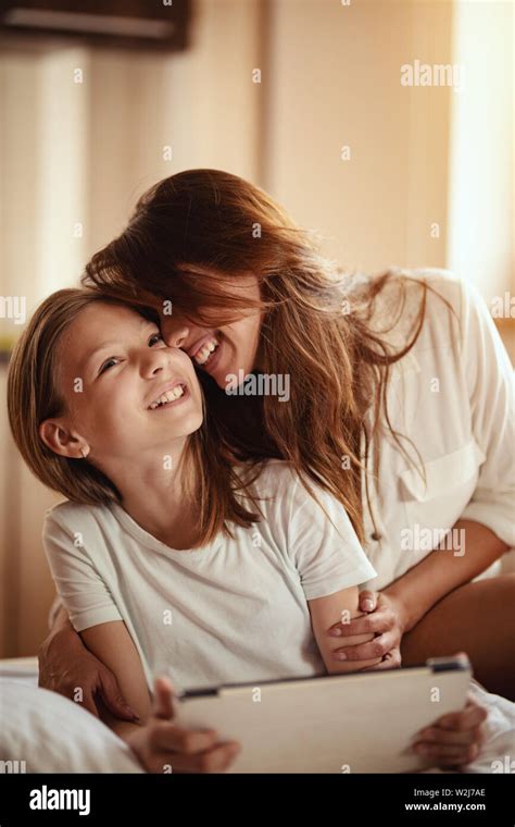 Happy Smiling Young Mother Is Embracing Her Daughter Who Is Holding A