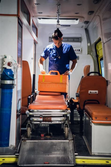 Paramedic Presses An Oxygen Mask To A Woman`s Face Who Is Lying On A