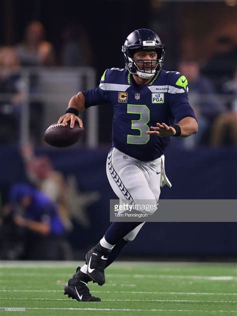 News Photo : Russell Wilson of the Seattle Seahawks looks for ...