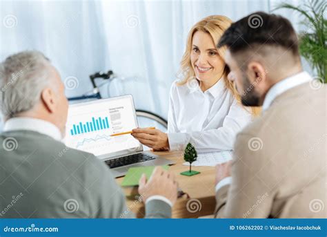 Responsible Worker Showing A Presentation On The Screen And Smiling