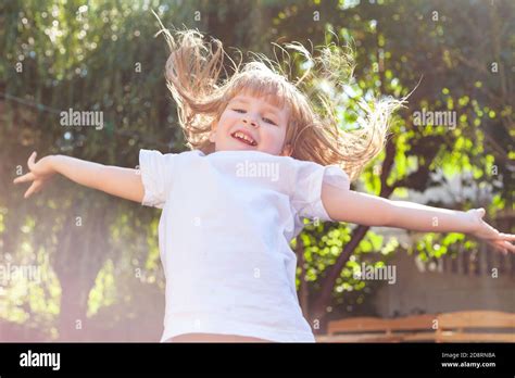 Gl Ckliches Kleines M Dchen Springen Aufgeregt Fliegende Haare Arme