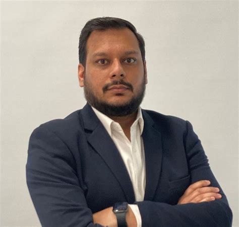 A Man With His Arms Crossed Wearing A Suit