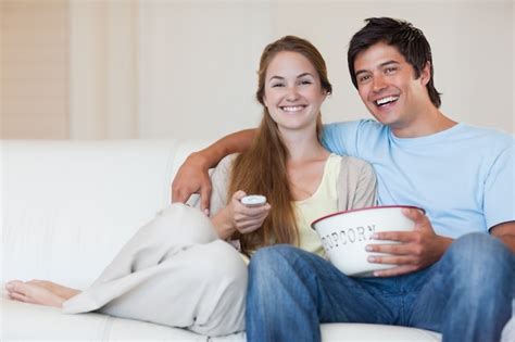 Premium Photo Couple Watching Television While Eating Popcorn