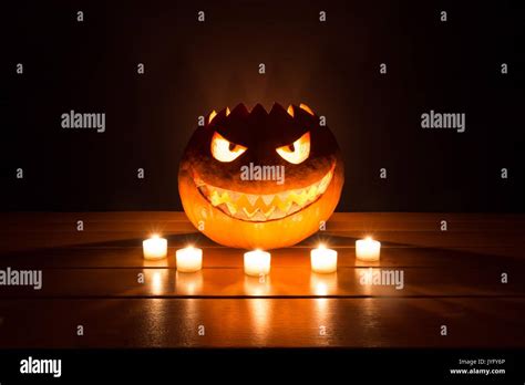 Spooky Smiling Halloween Pumpkin In Burning Fire Candles Flames The