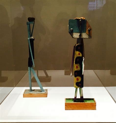 Two Wooden Sculptures Sitting On Top Of A White Table