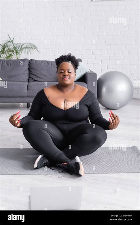 African American Plus Size Woman In Sportswear Sitting In Yoga Pose