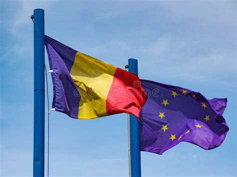 Romanian And European Union Flags Waving In The Wind Stock Photo