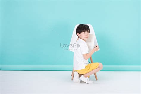 어린 남자 아이는 의자에 앉아 있다 사진 무료 다운로드 Lovepik