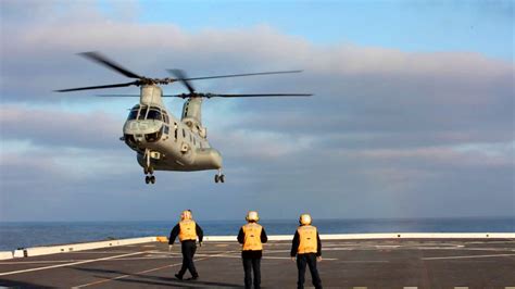 Landing Signalmen Direct A Ch 46e Sea Hawk Onto The Flight Deck Of The