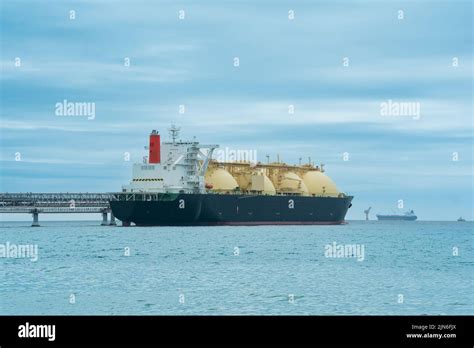 Liquefied Natural Gas Carrier Tanker During Loading At An Lng Offshore Terminal In The Distance