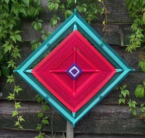 A Red Blue And Green Square Shaped Object Hanging From A Wooden Pole