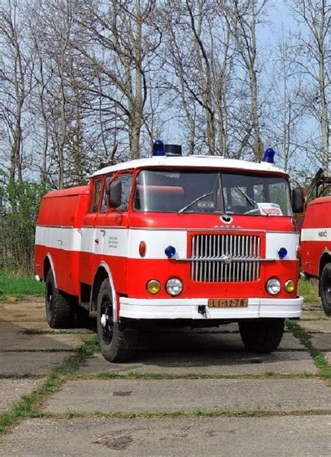 Two Red And White Fire Trucks Parked Next To Each Other