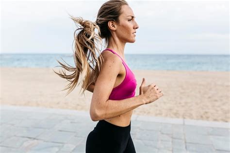 Premium Photo | Young woman running at the beach