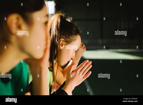 Side View Of Football Fans Praying Indoors Gym Pleading Girls