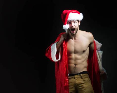 Sexy Père Noël Jeune homme musclé portant le chapeau du Père Noël